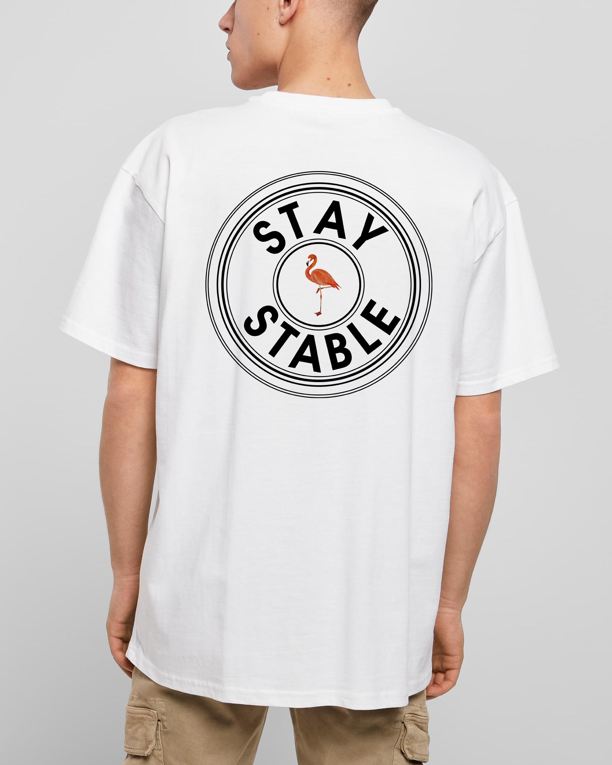 Person von hinten mit oversized T-Shirt in weiß mit schwarzem Oversized Stay Stable und Flamingo Print